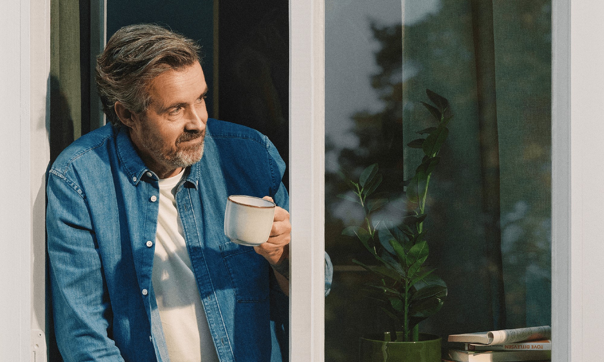 En man tittar ut genom ett fönster